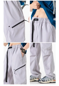 Macro detail of techwear cargo pants showing buckle belt, zippers and drawstring cuffs