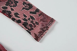 Détail de la manche en mesh transparent avec imprimé floral et couture d'ourlet