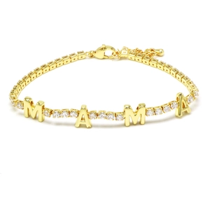Detail of a gold-plated tennis bracelet with MAMA lettering and white zircon stones