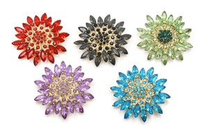 Close-up of five crystal sunflower brooches in red, grey, green, purple and blue tones