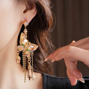 Vue rapprochée des boucles d'oreilles papillon avec cristaux ambrés et strass brillants