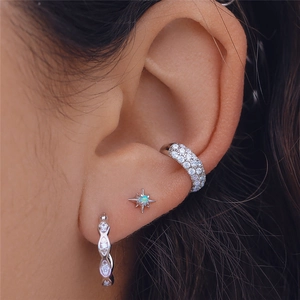 Macro shot of silver S925 opal star stud earrings and cubic zirconia ear cuffs set