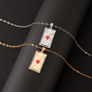 Gold and silver tarot-style Lovers necklaces with red heart pendants on black leather