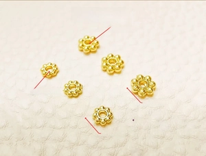 Detail of 18k gold plated snowflake spacers showing 4mm and 5mm diameter sizes