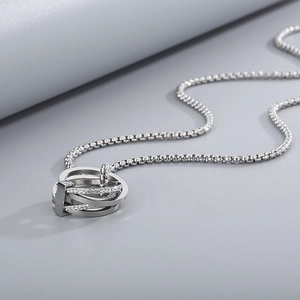 Detail of silver multilayer pendant necklace with interlocking cubic zirconia rings