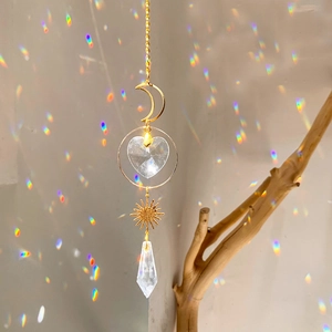 Detail of crystal suncatcher casting rainbow reflections with moon and sun motifs
