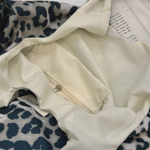 Detail of leopard print tote bag interior featuring inner zip pocket and cream lining