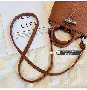 Detailed view of dark brown pebbled leather bucket bag with silver bamboo toggle closure