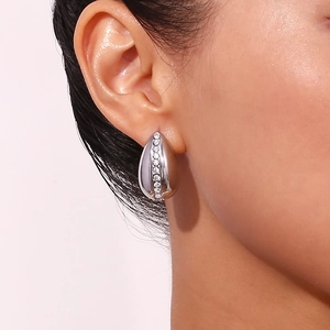 Macro shot of silver teardrop earrings featuring a row of inlaid white cubic zirconia stones
