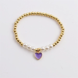 Elastic beaded bracelet featuring gold metal beads, white pearls, and a purple heart pendant