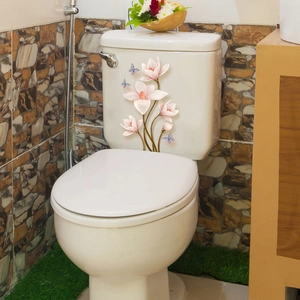 Dettaglio di adesivi con fiori di magnolia rosa e farfalle su sciacquone in ceramica