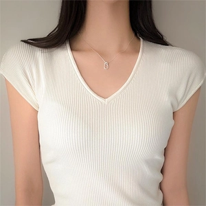 Close-up of a 925 sterling silver knotted pendant necklace worn on a woman's collarbone