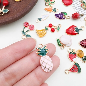 Detailed macro of colorful enamel fruit charms including pineapple and cherry for DIY jewelry