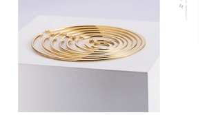 Detailed view of six pairs of polished gold hoop earrings in varying diameters