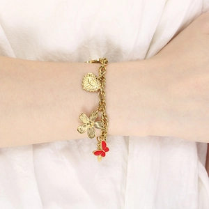 Close-up of 18K gold plated bracelet featuring heart, flower, and red butterfly charms