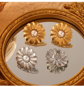 Détail de boucles d'oreilles fleur de marguerite en perles dorées et argentées avec textures