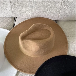 Détail de la texture d'un chapeau en laine camel avec bords noir et blanc contrastés