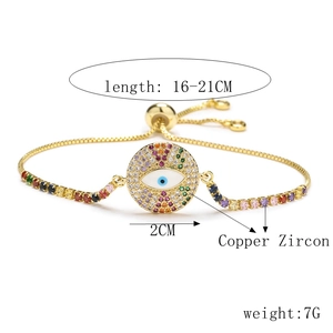 Detail of adjustable gold-plated bracelet with rainbow zircon evil eye palm charm