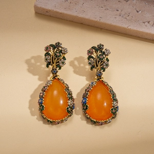 Détail de boucle d'oreille vintage en résine orange avec cristaux multicolores
