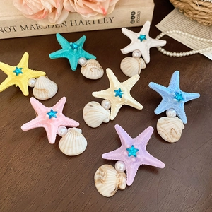 Close-up of starfish and shell hair clips with rhinestones in seven pastel colors