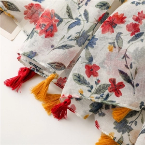 Close-up of cotton linen texture with floral patterns and colorful tassels