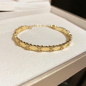 Detailed close-up of 18k gold plated iris cuff bracelet with white zircon inlay details