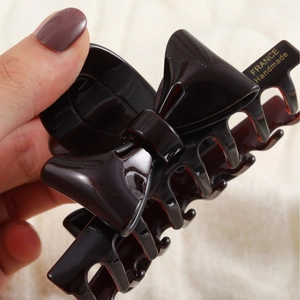 French vintage dark brown bow hair claw clip in a high-gloss finish with gold lettering
