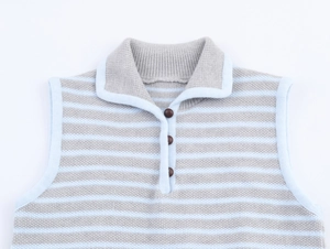 Dettaglio del gilet in maglia a righe con colletto a risvolto e tre bottoni frontali