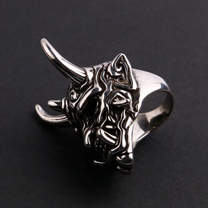 Silver stainless steel demon mask skull ring for men on a dark textured background