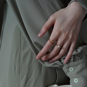 Close-up of elegant gold plated silver rings with pearl and diamonds on model hand