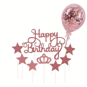 Close-up of rose gold glitter Happy Birthday topper set with stars, crown and confetti balloon