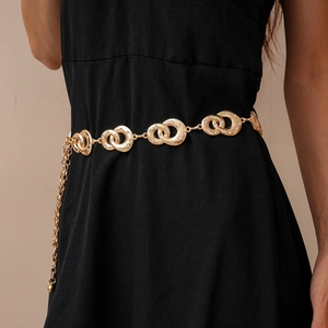 Detail of geometric interlocking gold chain belt with rhinestones on a black dress