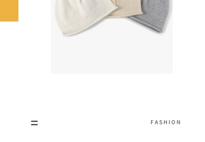 Close-up of beige and grey knit beanies showing soft wool texture and rolled edge