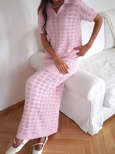 Detail of pink knitted two-piece set featuring delicate heart-shaped hollow-out patterns