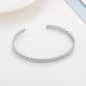Vue détaillée du bracelet jonc tressé en acier inoxydable argenté avec texture torsadée