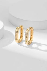 Detail of gold square hoop earrings with screw motifs and crystal cross accents
