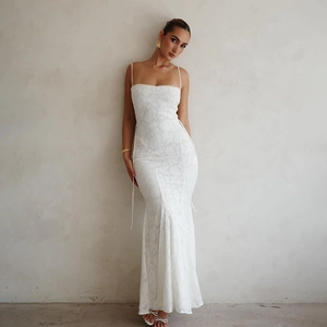 Détail de robe longue blanche en dentelle avec dos nu à lacets et coupe sirène ajustée