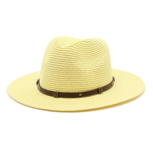 Detail of straw hat with brown leather band featuring vintage metal rivets and studs