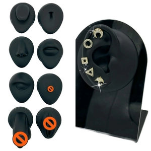 Detailed black silicone ear model showing gold piercing jewelry for piercing practice