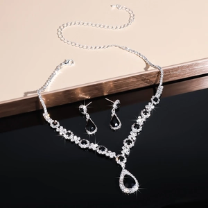 Detailed macro view of silver necklace and earrings set with teardrop black crystals