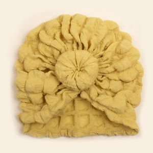 Close-up of yellow baby turban hat featuring a waffle texture knit and soft knot detail