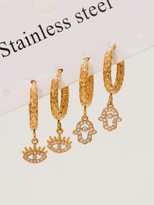 Detail of gold stainless steel earrings with evil eye and hamsa hand zircon pendants