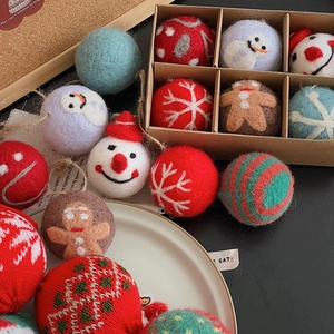 Detailed view of handmade Christmas felt and wool balls in a kraft gift box