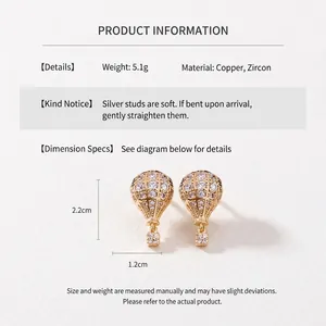 Détail des boucles d'oreilles montgolfière dorées avec zircons et tiges en argent
