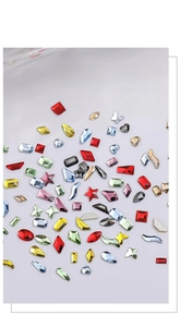 Macro shot of mixed sparkling crystal nail rhinestones in various shapes and vibrant colors