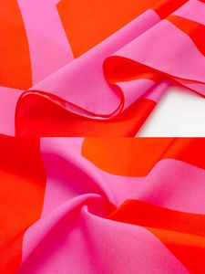 Detail of orange and pink geometric contrast crepe fabric with fine rolled edge finish