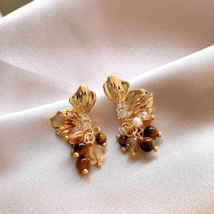 Vintage gold petal earrings with tiger eye stone and pearls on champagne satin fabric