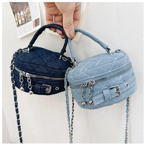 Detail of denim mini quilted box bags featuring chain straps and metallic ball pendants