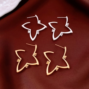 Detailed close-up of 18K gold and silver plated starburst hollow stud earrings on velvet