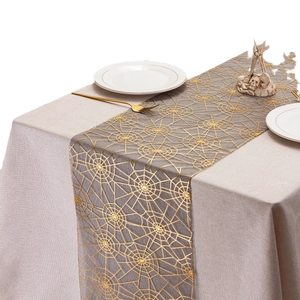 Halloween table runner with golden spider web pattern on grey woven fabric for dining decor